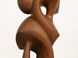 sculpture made of wood on a white pedestal against a white background