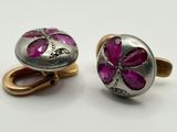deux paires de boutons de manchette en argent sertis de pierres roses, posés sur un fond blanc