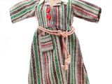 robe rayée posée sur un socle de mannequin orné d'un bouton rouge