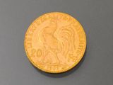 a close up of a gold coin on a gray surface