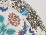a close up of a plate with a flower design on it