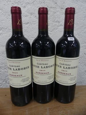trois bouteilles de vin posées sur une table en bois