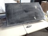 a blackboard sitting on top of a desk next to a remote control