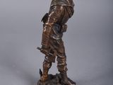bronze figurine of a man with a bird on his shoulder