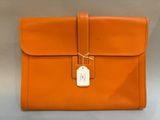 an orange leather briefcase with a tag on it