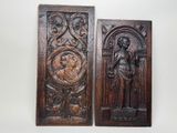 deux plaques en bois sur lesquelles sont sculptés un homme et une femme