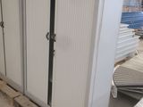 une grande armoire blanche dans un entrepôt où se trouvent de nombreuses palettes