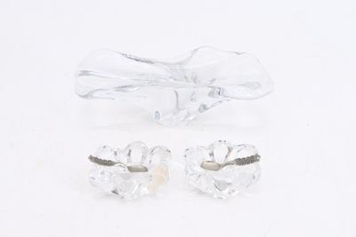 pair of clear crystal earrings and a bow on a white surface