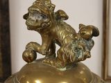 a statue of a dog sitting on top of a bowl