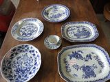 several blue and white plates and bowls on a wooden table