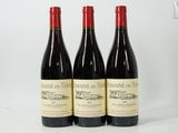 trois bouteilles de vin rouge posées côte à côte sur une table