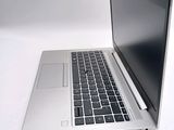 a silver laptop with a black keyboard on a white surface