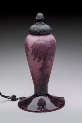purple glass vase with a black lid on a white surface