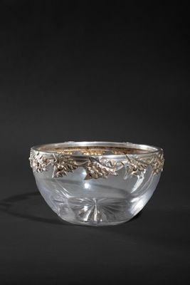 a silver and glass bowl on a black background