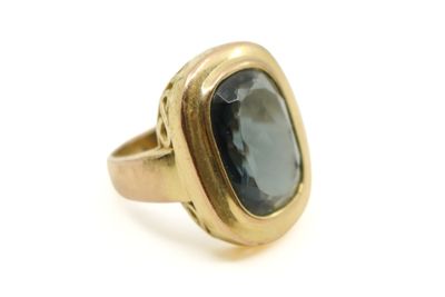 gros plan d'une bague en or avec une pierre bleue