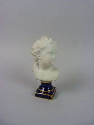 un buste de femme blanc posé sur un socle bleu et or