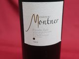 a bottle of wine sitting on top of a red cloth