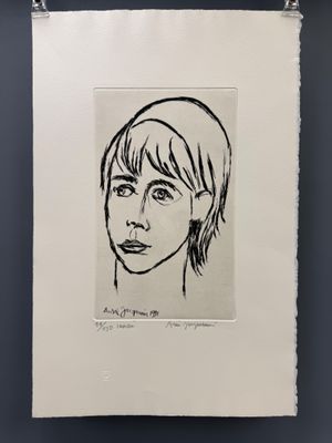 un dessin en noir et blanc représentant le visage d'une femme, accroché au mur