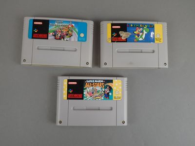 trois cartouches de jeux nintendo posées sur une table