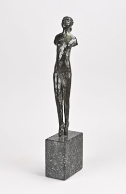 une statue représentant une femme debout sur un bloc de marbre