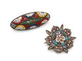 two small brooches with colorful designs on them sitting next to each other