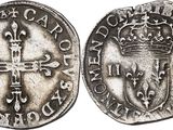 a silver coin with a cross and a crown on it