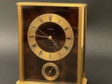 a gold clock with roman numerals on the face
