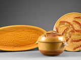 yellow and brown ceramic dishes and a bowl on a gray surface
