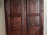 a wooden armoire with carvings on it in a room