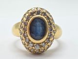 an image of a gold ring with a blue stone surrounded by white diamonds