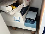 a small refrigerator in the corner of a room with boxes on the floor