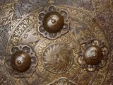 close up of a large metal plate with decorative designs on it