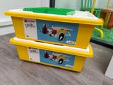 deux boîtes jaunes ornées de Lego, posées par terre