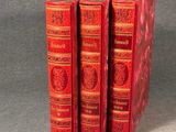 trois livres rouges superposés sur une table