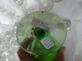 a person holding a green glass with a label on it