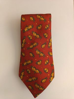 an orange neck tie with a yellow bird design on it