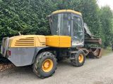 une photo d'un tracteur jaune et noir garé sur le bord de la route