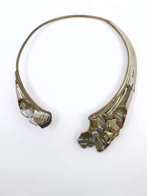 a close up of a silver necklace with a flower design on it