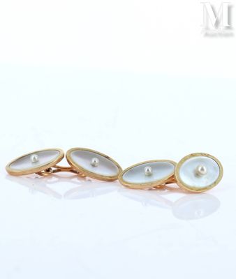 a close up of a pair of gold and pearl cufflinks