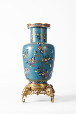 un vase bleu posé sur un socle, sur une surface blanche