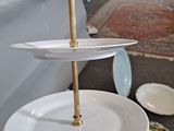 a person holding a three tiered plate with plates on it