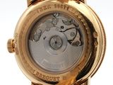 a close up of a gold wrist watch with a white dial