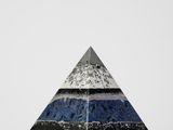 un gros plan d'un objet en forme de pyramide posé sur une surface blanche
