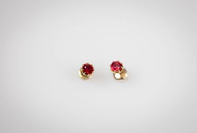 une paire de boucles d'oreilles rouges et dorées sur fond blanc