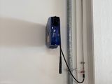 un chauffe-eau fixé au mur, à côté d'un tuyau