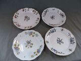 quatre assiettes à motifs floraux posées sur une table