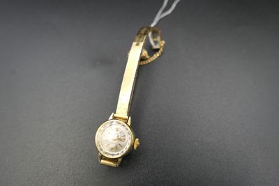 an image of a gold watch with a white face on a black surface