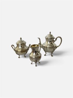 un ensemble de trois théières et cafetières en métal argenté
