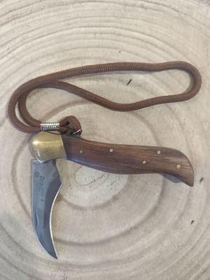 a small knife with a brown handle on a white plate