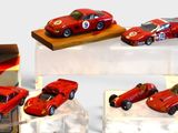 four red toy cars on display in a display case